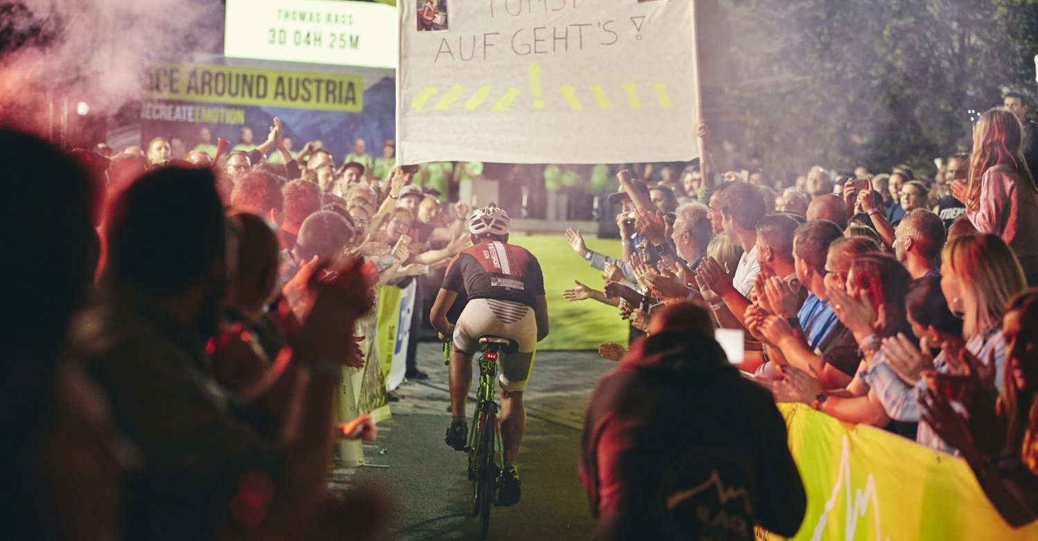 Zieleinlauf eines Radfahrers beim Race Around Austria mit tausenden Fans bei Nacht. Zieleinlauf eines Radfahrers beim Race Around Austria mit tausenden Fans bei Nacht.