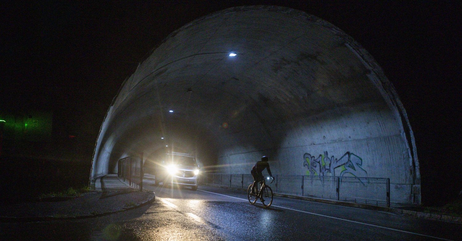 Radfahrer beim Race Around Austria fährt aus einem Tunnel bei Nacht Radfahrer beim Race Around Austria fährt aus einem Tunnel bei Nacht
